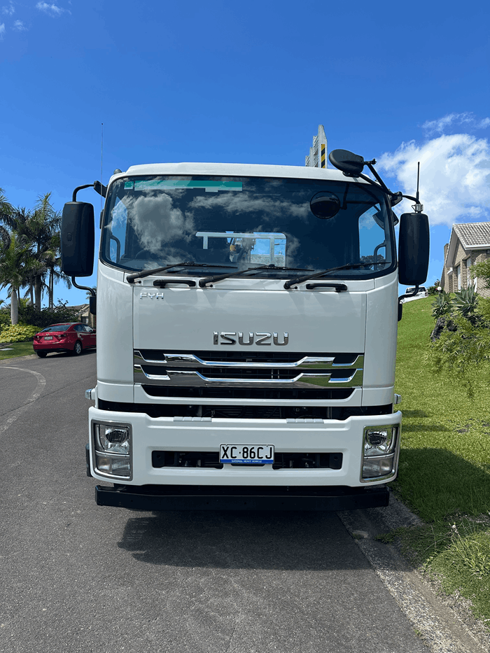 Front of the white Isuzu truck parked beside a grass verge