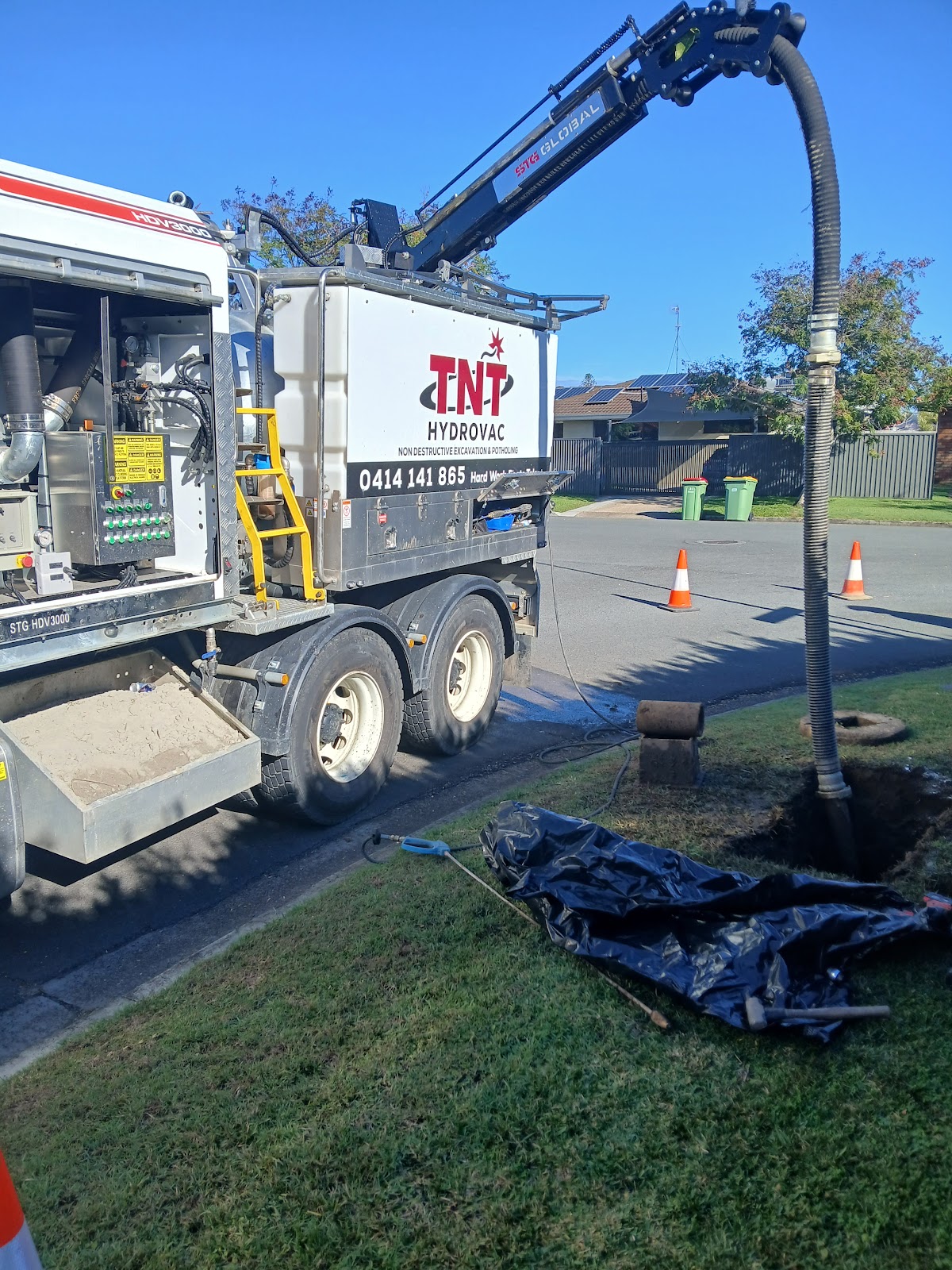 TNT HydroVac truck and vacuum hose at a grass verge TNT HydroVac truck and vacuum hose at a grass verge