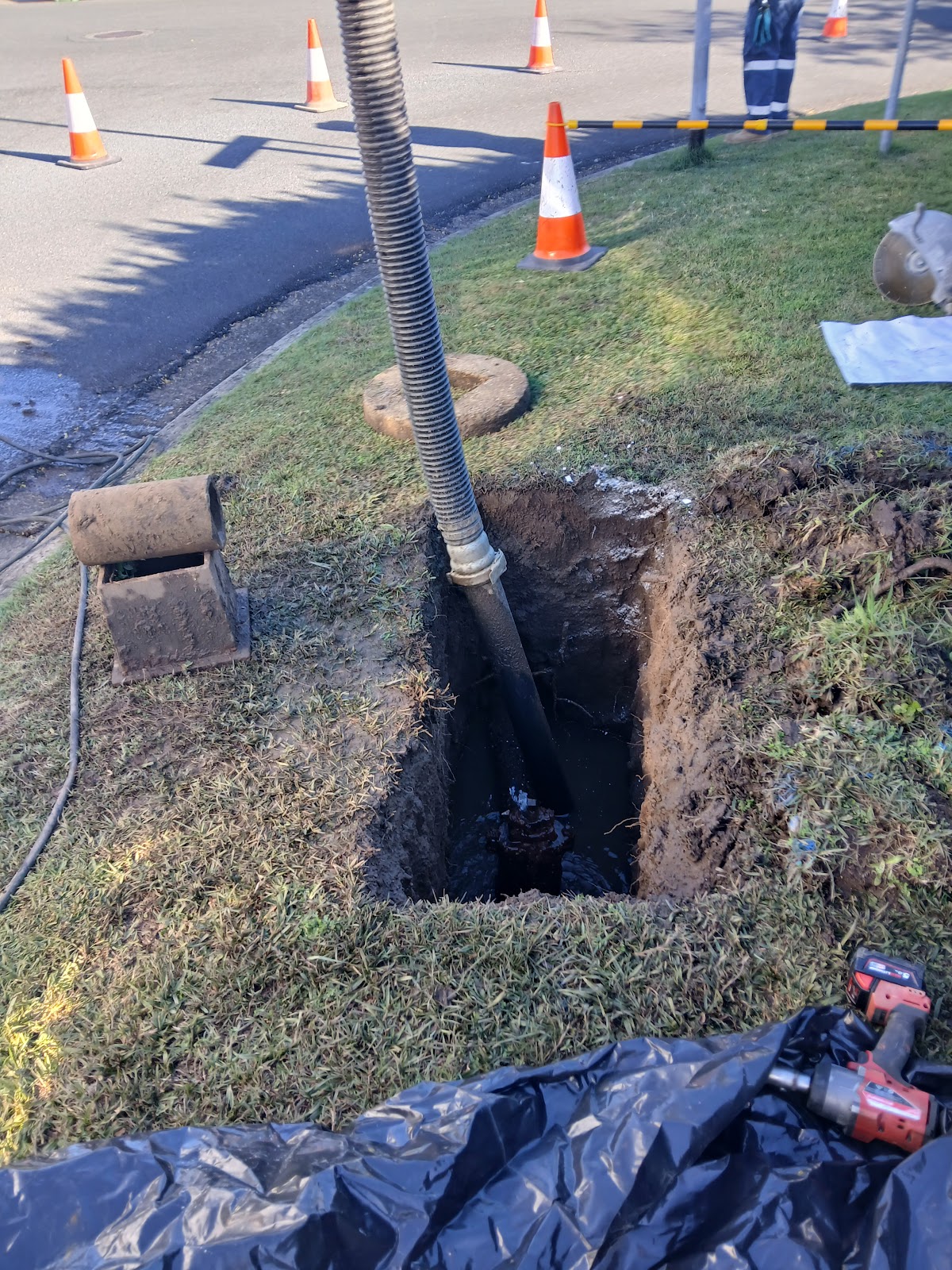 Vacuum hose entering an excavated hole beside traffic cones Vacuum hose entering an excavated hole beside traffic cones, supplied with Dave Alexander's Google review, photo 2