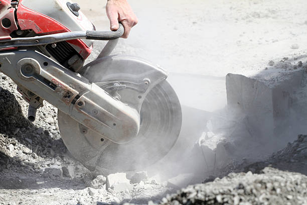 Powered concrete saw cutting a concrete surface